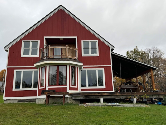 rear view of house featuring a yard and a balcony