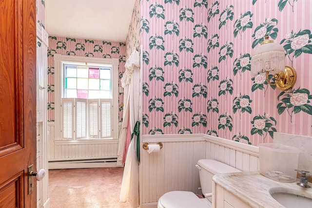 bathroom with a baseboard radiator, wallpapered walls, toilet, and a wainscoted wall