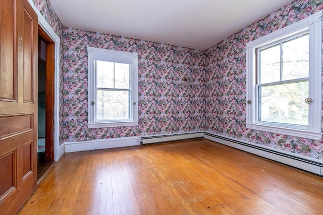 empty room with baseboards, light wood-style floors, and wallpapered walls