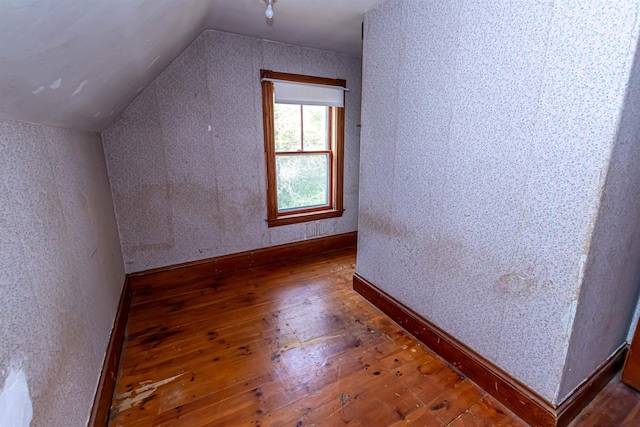 bonus room featuring hardwood / wood-style floors, vaulted ceiling, and baseboards