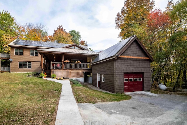 view of front of property featuring solar panels, covered porch, and a front yard