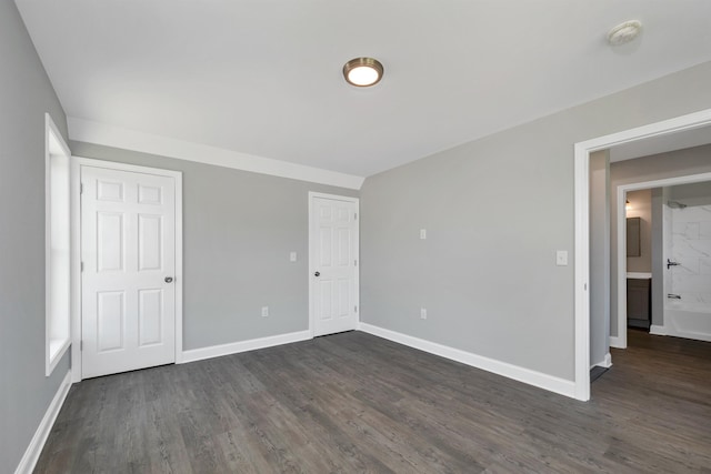 spare room featuring dark wood-style floors and baseboards