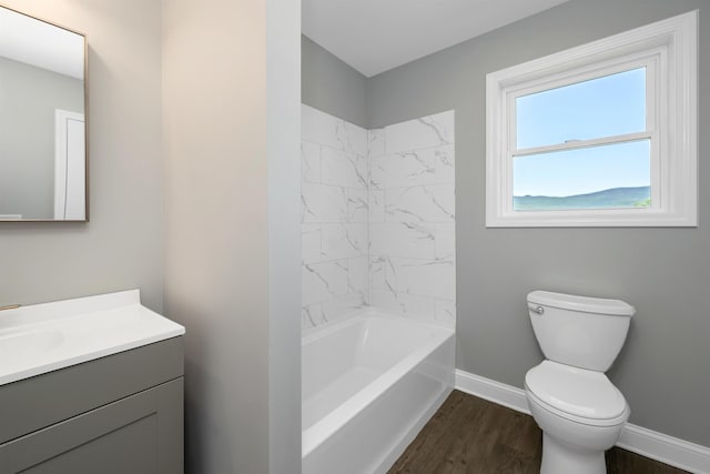 bathroom featuring baseboards, toilet, bathing tub / shower combination, wood finished floors, and vanity