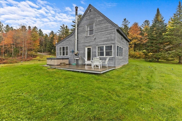 rear view of property featuring a lawn and a deck