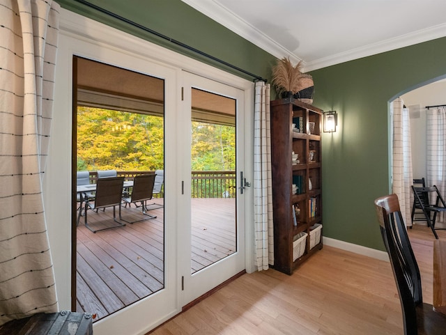 doorway to outside with crown molding and light hardwood / wood-style flooring