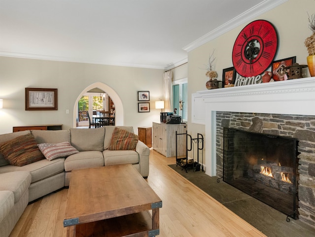 living room featuring crown molding, wood-type flooring, and a fireplace