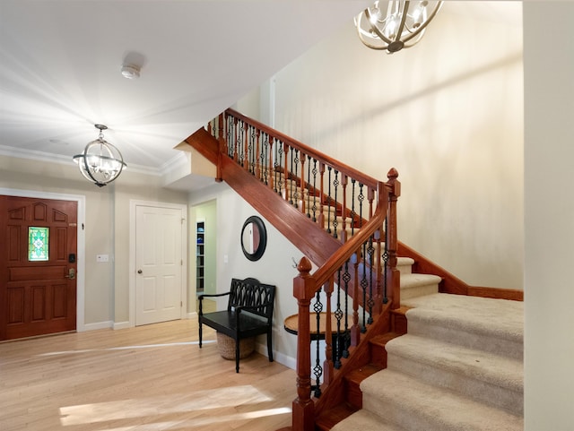 entryway with hardwood / wood-style floors, a chandelier, and ornamental molding