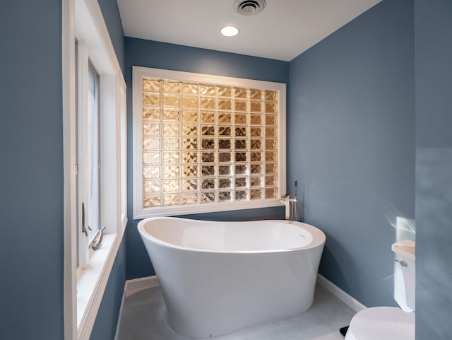 bathroom featuring a tub and toilet