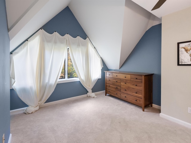 bedroom featuring light colored carpet, vaulted ceiling, and ceiling fan