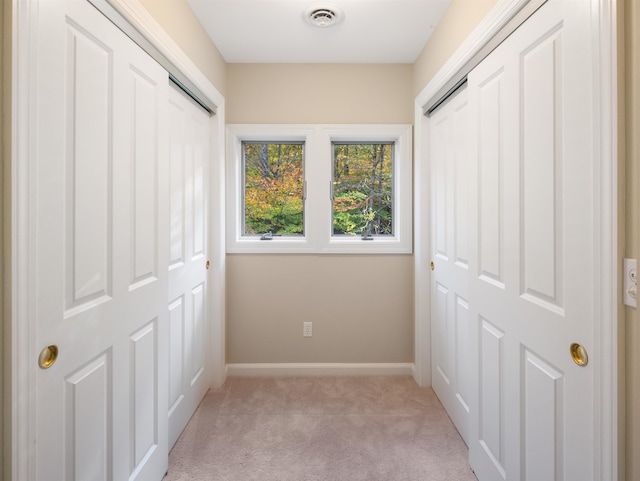 unfurnished bedroom with light carpet and a closet