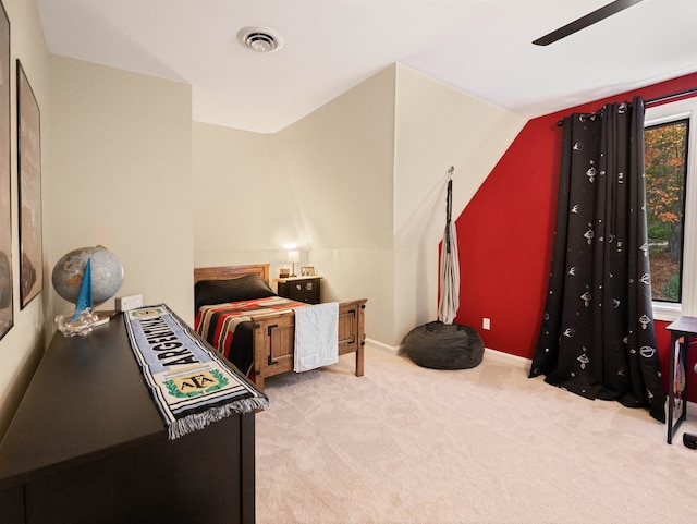 carpeted bedroom with ceiling fan and vaulted ceiling