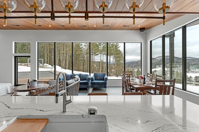 interior space featuring wooden ceiling, sink, a wealth of natural light, and a mountain view