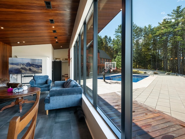 entryway with wood ceiling, vaulted ceiling, and a wealth of natural light