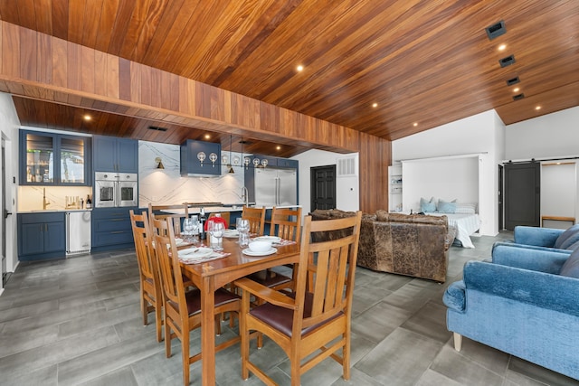 dining space featuring lofted ceiling, a barn door, and wood ceiling