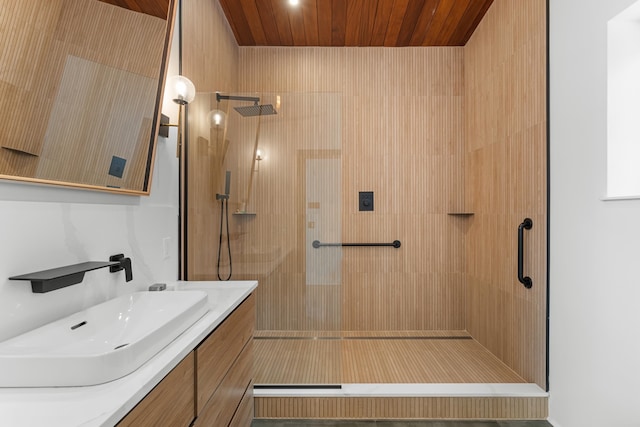 bathroom featuring wooden ceiling, a shower with door, and vanity