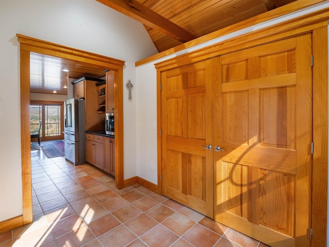 hall featuring wood ceiling, lofted ceiling with beams, and light tile patterned floors