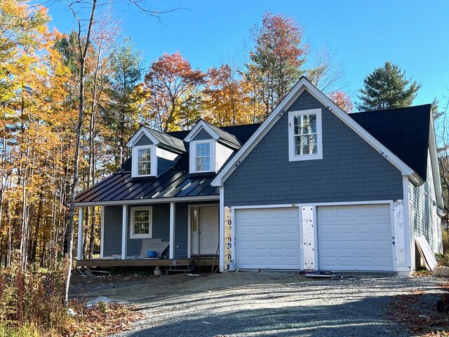 cape cod home featuring a porch and a garage