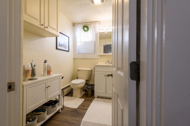 bathroom featuring vanity, toilet, a textured ceiling, and hardwood / wood-style flooring