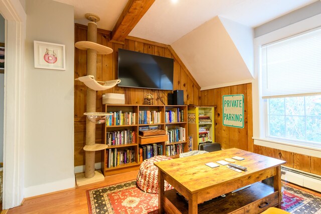 office area with lofted ceiling with beams, wooden walls, a baseboard heating unit, and light hardwood / wood-style flooring