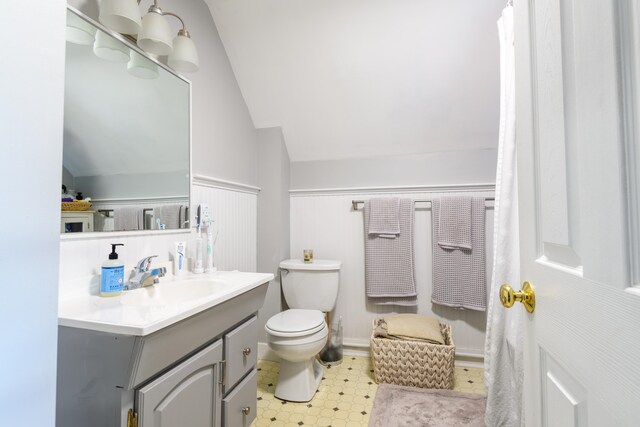 bathroom with lofted ceiling, vanity, and toilet