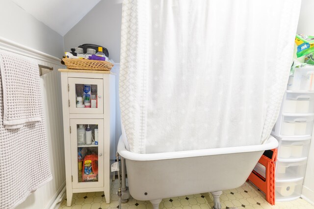 bathroom featuring a bathtub and lofted ceiling