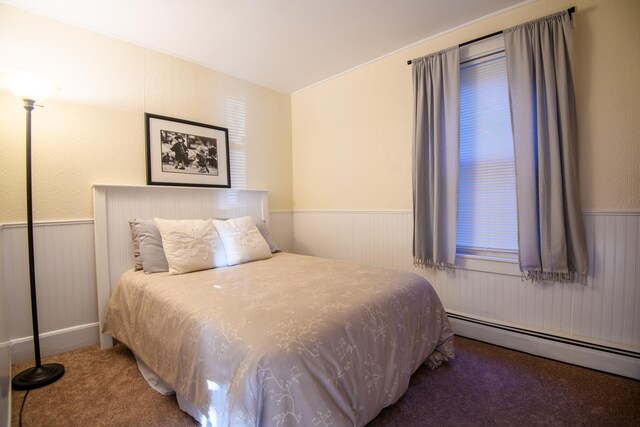 carpeted bedroom with a baseboard heating unit