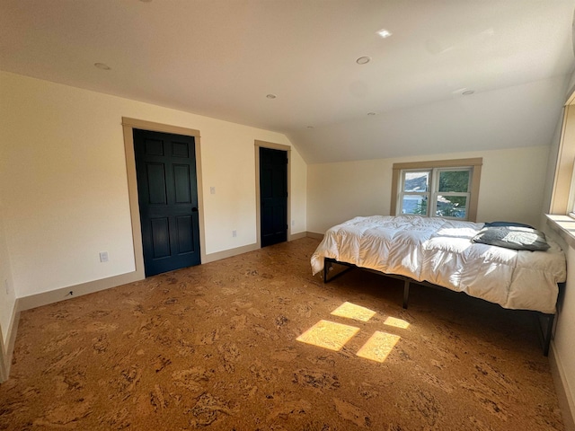 carpeted bedroom with lofted ceiling