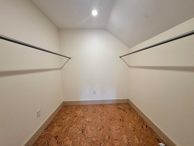 spacious closet with vaulted ceiling and carpet