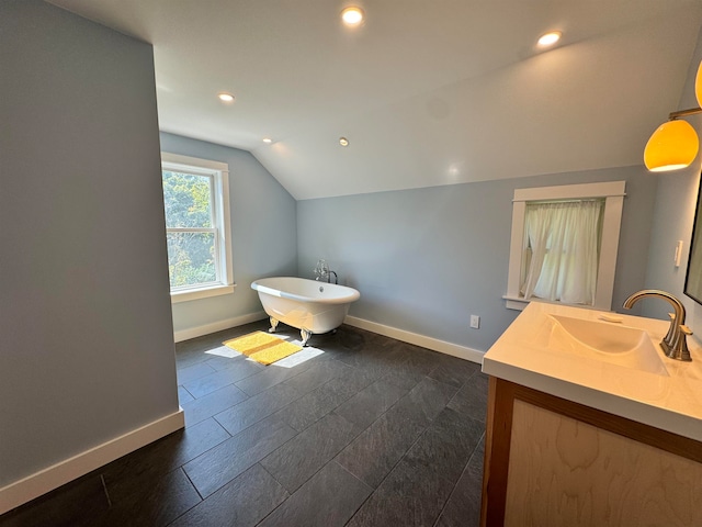 bathroom with vanity, lofted ceiling, a bath, and hardwood / wood-style flooring