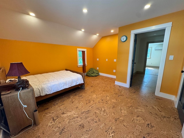 carpeted bedroom featuring an AC wall unit and lofted ceiling