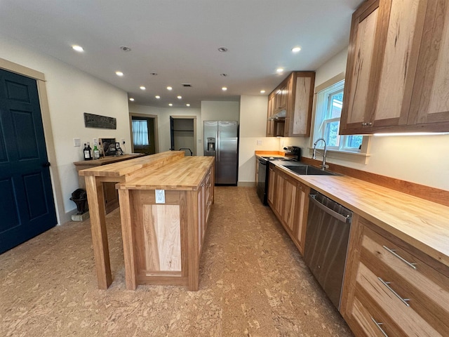 kitchen with stainless steel appliances, wooden counters, and sink