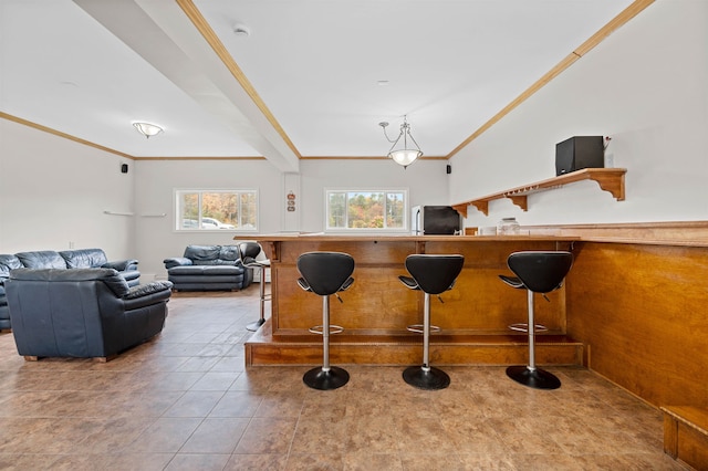 interior space with light tile patterned floors, black fridge, ornamental molding, and a breakfast bar