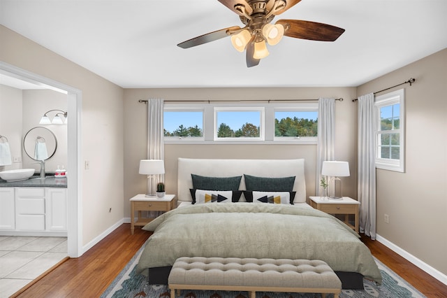 bedroom with ceiling fan, light hardwood / wood-style flooring, and multiple windows