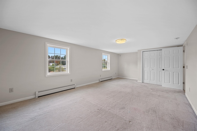 unfurnished bedroom with light carpet and a baseboard radiator