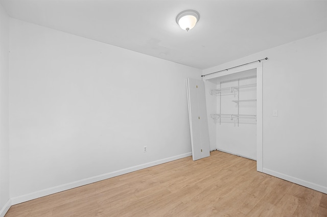 unfurnished bedroom featuring light wood-type flooring and a closet