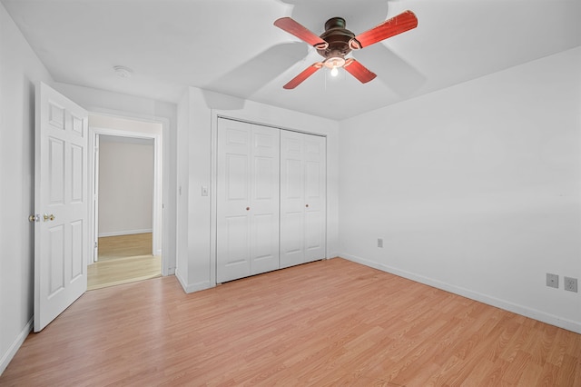 unfurnished bedroom featuring a closet, light hardwood / wood-style flooring, and ceiling fan