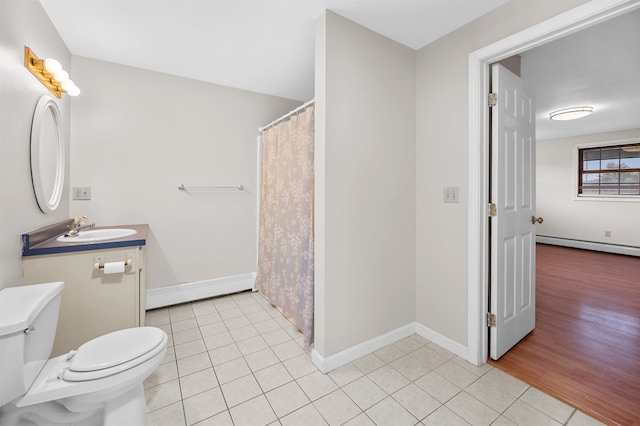 bathroom with toilet, vanity, wood-type flooring, and baseboard heating