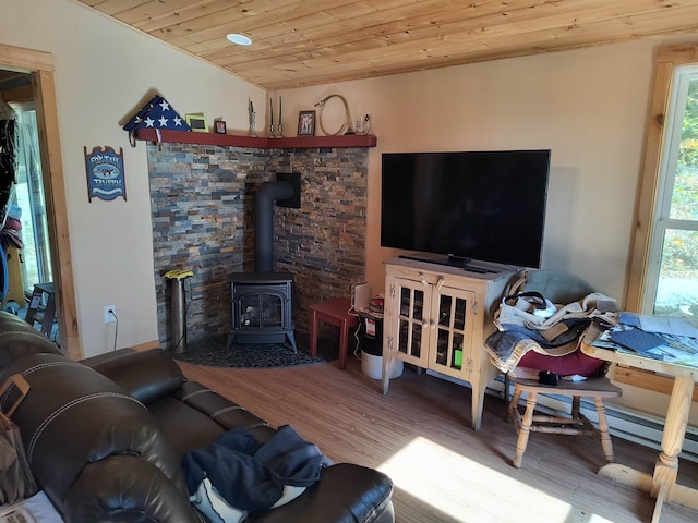 living room featuring a wood stove, hardwood / wood-style floors, and wooden ceiling