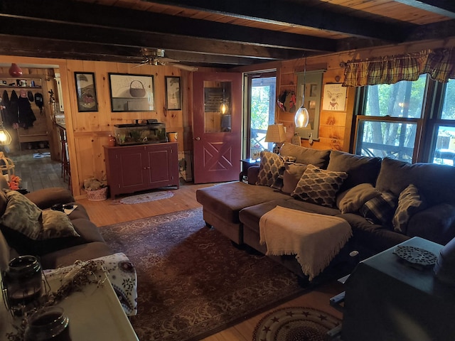 living room featuring hardwood / wood-style flooring, beam ceiling, and wood walls