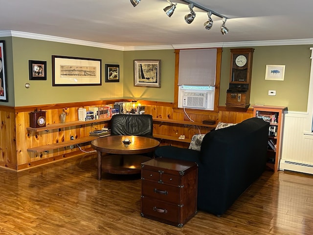 living room with baseboard heating, dark hardwood / wood-style floors, cooling unit, track lighting, and ornamental molding