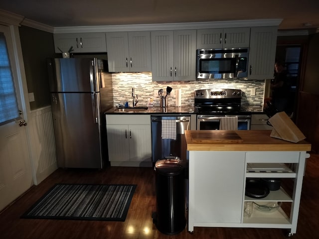 kitchen featuring dark hardwood / wood-style flooring, stainless steel appliances, crown molding, sink, and butcher block countertops