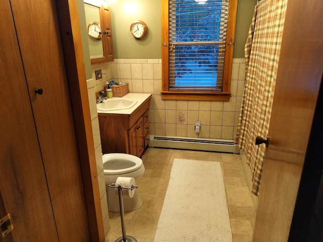 bathroom featuring tile patterned floors, vanity, a baseboard heating unit, tile walls, and toilet