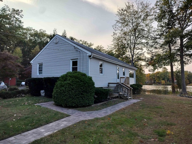 property exterior at dusk with a lawn