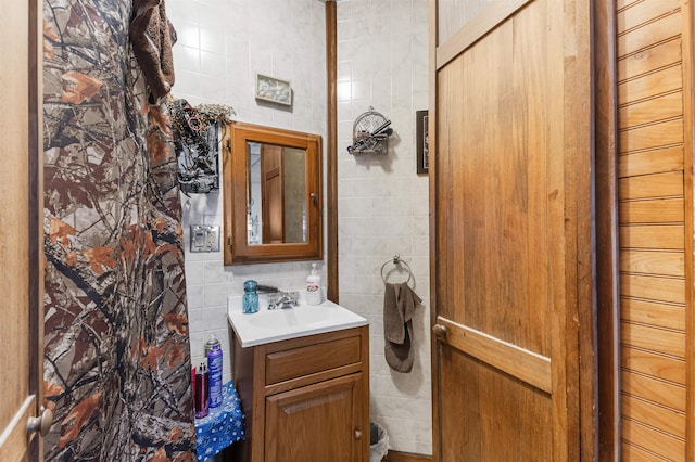 bathroom with vanity and tile walls