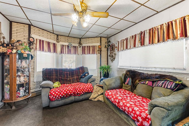 carpeted living room featuring a drop ceiling, a wealth of natural light, and ceiling fan