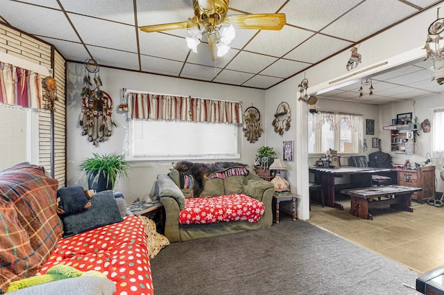 tiled living room featuring a drop ceiling and ceiling fan