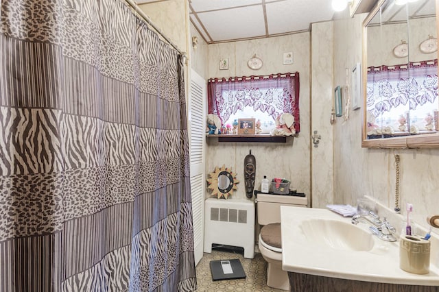 bathroom featuring a drop ceiling, radiator, toilet, a shower with shower curtain, and vanity