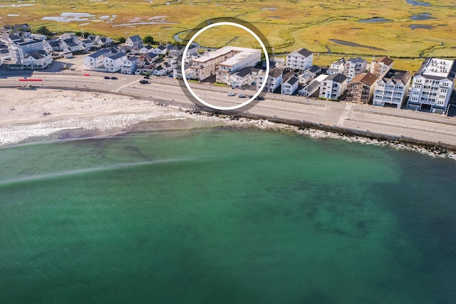 bird's eye view with a water view and a beach view