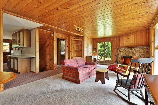 living room featuring wooden ceiling, light colored carpet, wooden walls, and a stone fireplace