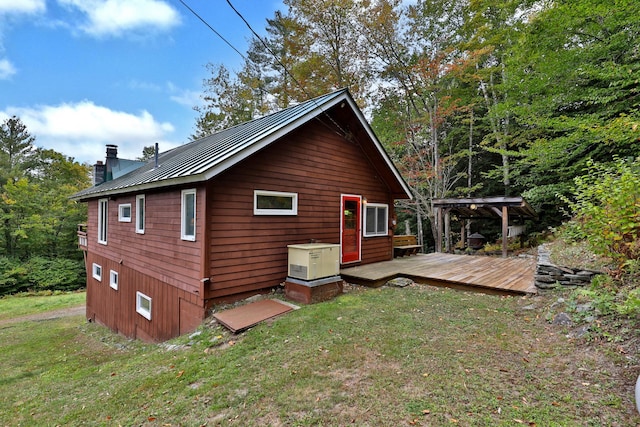 view of home's exterior featuring a wooden deck and a lawn